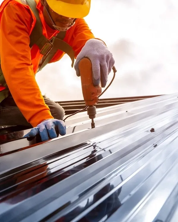 DUBCO worker installing metal roofing panels on a commercial building.